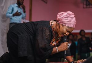 a woman in a pink turban is holding a microphone