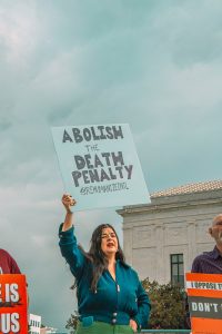 a woman holding a sign in front of a building