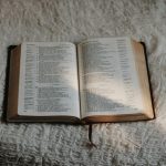 opened book on white textile