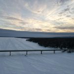 a snowy landscape with a fence and trees
