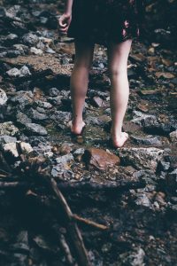 woman standing on rocks with water flowing