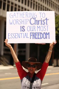Woman holds a Christian freedom sign in Los Angeles street protest.