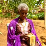 a woman sitting in a chair holding a musical instrument