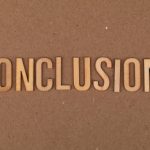 Wooden letters arranged to spell 'Conclusion' on a brown cardboard background.