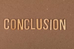 Wooden letters arranged to spell 'Conclusion' on a brown cardboard background.
